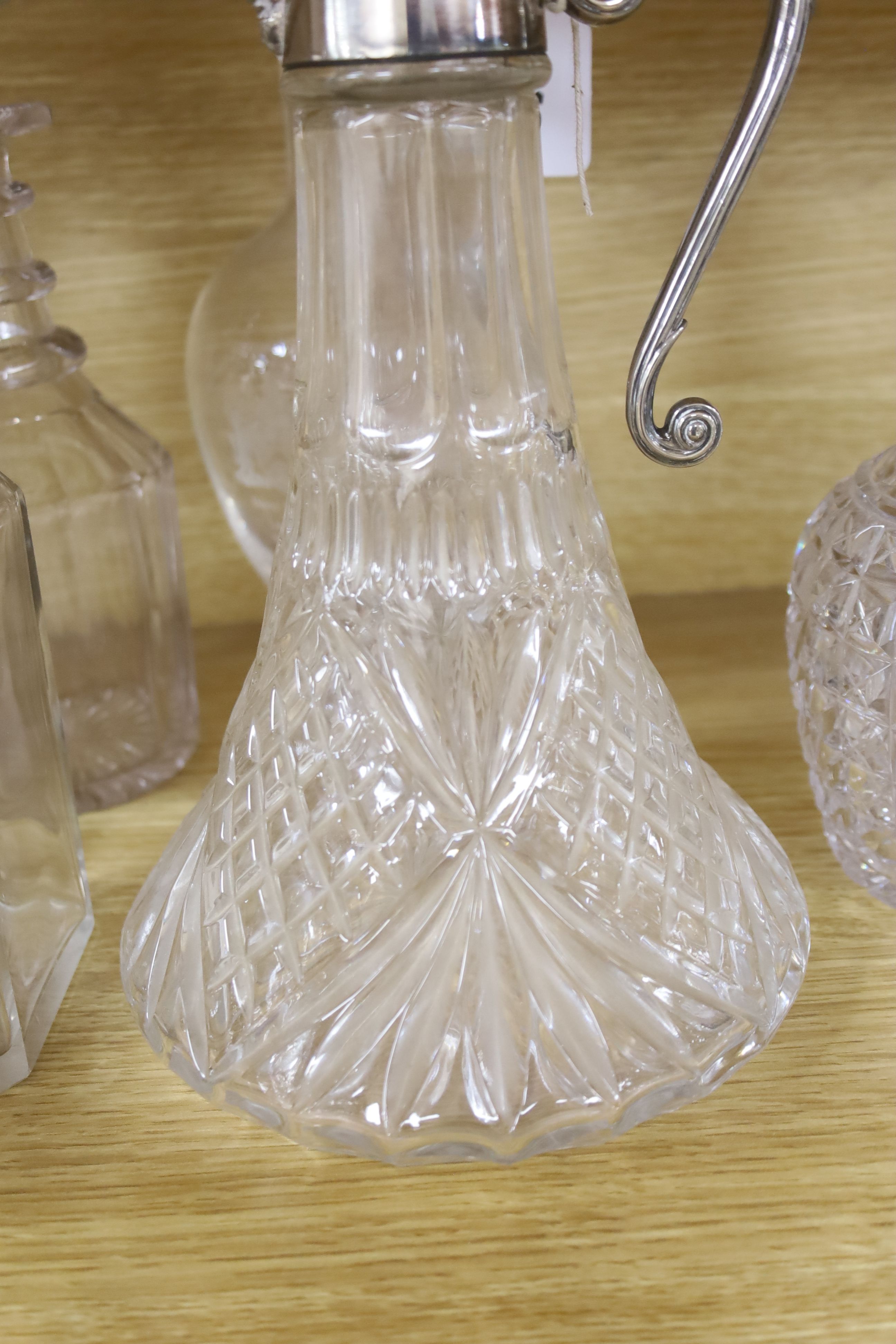 A silver mounted decanter, various other decanters, a claret jug and a jug